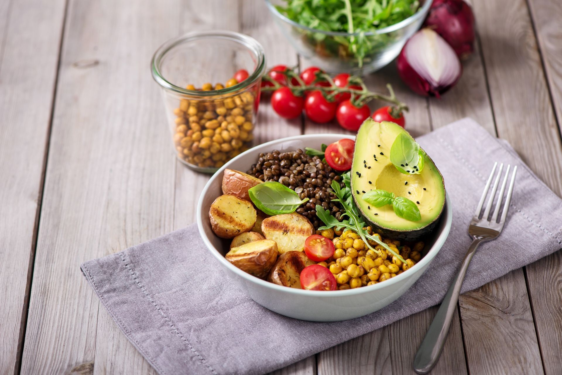 Buddha bowl with baked potatoes, lentils and spicy chickpeas, avocado, arugula, vegan, vegetarian healthy food 